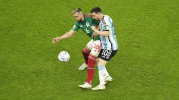 Mexico's Hector Herrera and Argentina's Lionel Messi battle for possession during the World Cup group C soccer match between Argentina and Mexico, at the Lusail Stadium in Lusail, Qatar, Saturday, Nov. 26, 2022. (AP Photo/Darko Bandic)