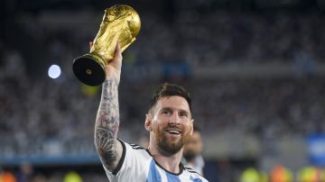 Argentina's Lionel Messi hoists the winning team replica of the FIFA World Cup trophy during a celebration ceremony for local fans after an international friendly soccer match against Panama at the Monumental stadium in Buenos Aires, Argentina, Thursday, March 23, 2023. (AP Photo/Gustavo Garello)