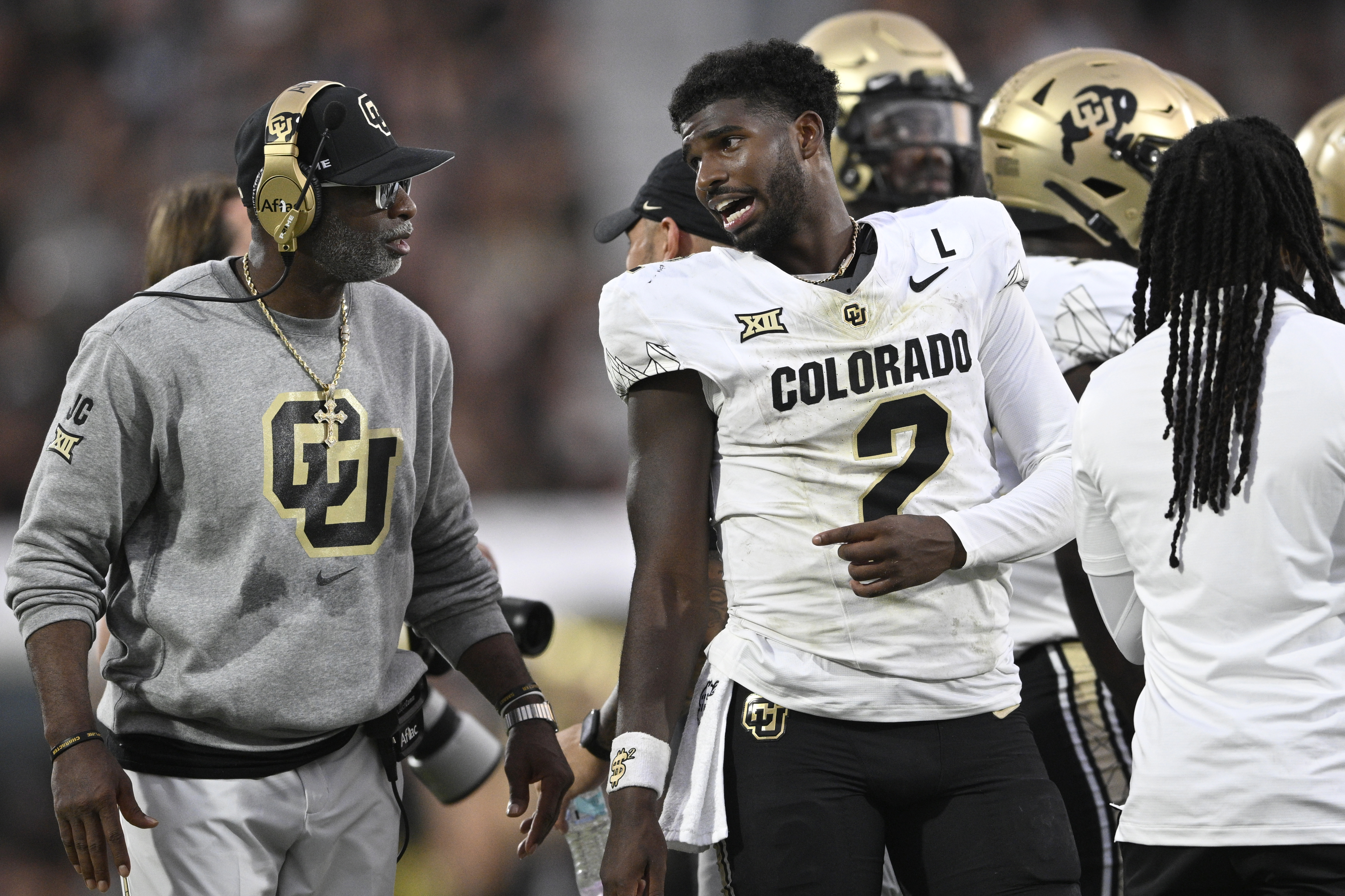 Shedeur Sanders charla con su padre, Deion Sanders, durante un partido de los Buffaloes de Colorado en 2024. El talentoso quarterback tuvo que esperar hasta el tercer día del Draft de la NFL para ser seleccionado.