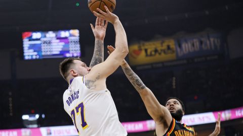 Los Angeles Lakers guard Luka Doncic (77) looks to shoot over Oklahoma City Thunder forward Kenrich Williams (34) during the first half of an NBA basketball game Sunday, April 6, 2025, in Oklahoma City. (AP Photo/Nate Billings)