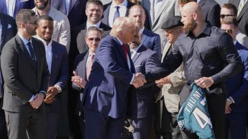 El presidente Donald Trump recibe un jersey con su apellido en el dorsal de manos de Lane Johnson.