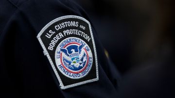 A customs agent wears a patch for the U.S. Customs and Border Protection agency, which is a part of the Department of Homeland Security, Friday, Oct. 27, 2017, at John F. Kennedy International Airport in New York. (AP Photo/Mark Lennihan)