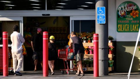 Customers enter a Trader Joe's market in the Silver Lake neighborhood of Los Angeles on Thursday, Aug. 2, 2018. The Los Angeles grocery store where a manager was accidentally killed by police during a gun battle with a suspect has reopened. The market reopened its doors Thursday with a sign telling customers, "We missed you." (AP Photo/Richard Vogel)