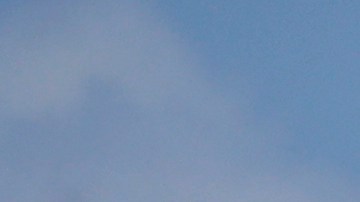 A surfer with a child walks on the mostly empty Santa Monica beach Sunday, March 29, 2020, in Los Angeles. With cases of coronavirus surging and the death toll increasing, lawmakers are pleading with cooped-up Californians to spend a second weekend at home to slow the spread of the infections. (AP Photo/Marcio Jose Sanchez)