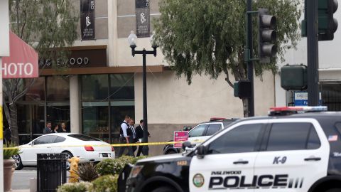 Investigators leave the Church of Scientology, at left rear, after a shooting in Inglewood, Calif., Wednesday, March 27, 2019. Two police officers and a suspect were shot Wednesday after law enforcement responded to reports of a man with a sword entering the Church of Scientology in Inglewood, authorities said. (AP Photo/Reed Saxon)