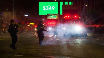 Los Angeles police officers attempt to disperse rowdy fans in the street, Sunday, Oct. 11, 2020, in Los Angeles, after the Los Angeles Lakers defeated the Miami Heat in Game 6 of basketball's NBA Finals to win the championship. (AP Photo/Jintak Han)