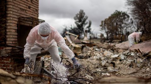 Volunteers from Samaritan's Purse help search a home for items that survived the Eaton Fire, Thursday, Feb. 6, 2025, in Altadena, Calif. (AP Photo/Ethan Swope)