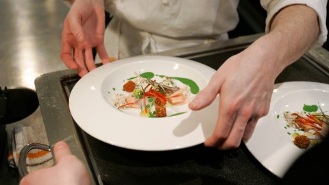 FILE - In this April 3, 2008 file photo, chef Grant Achatz places one of the many courses on a server's tray in the Alinea restaurant kitchen in Chicago. On Tuesday, Nov. 16, 2010, Alinea and one other Chicago restaurant, L20, received the rare and coveted three-star rating in the city's first edition of the Michelin Guide. (AP Photo/Charles Rex Arbogast, File)