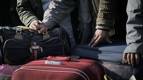 Egyptians, who used to work in Libya, wait with their belongings for buses to take them further inland, after they fled Libya, at the Tunisia-Libyan border, in Ras Ajdir, Tunisia, on Friday, Feb. 25, 2011. (AP Photo/Lefteris Pitarakis)