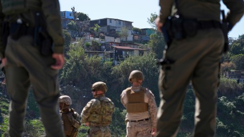 Agentes de CBP y militares observan Tijuana desde la frontera de EE.UU. con México en San Diego.