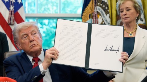 El presidente Donald Trump muestra una orden ejecutiva sobre educación junto a la secretaria de Educación Linda McMahon.