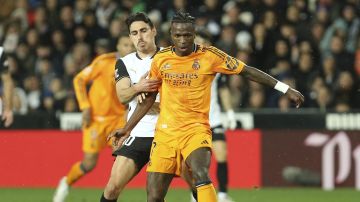 Real Madrid's Vinicius Junior, front, and Valencia's Andre Almeida battle for the ball during a Spanish La Liga soccer match at Mestalla stadium in Valencia, Spain, Friday, Jan. 3, 2025. (AP Photo/Alberto Saiz)