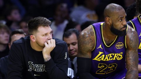 Los Angeles Lakers guard Luka Doncic, left, and forward LeBron James, right, follow the action on the floor from the bench during the first half of an NBA basketball game against the Golden State Warriors, Thursday, Feb. 6, 2025, in Los Angeles. (AP Photo/Kevork Djansezian)