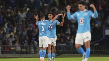 Angel Sepulveda of Mexico's Cruz Azul, center, is congratulated after scoring his side's opening goal against Mexico's America during a CONCACAF Champions Cup second leg quarterfinal soccer match in Mexico City, Tuesday, April 8, 2025. (AP Photo/Eduardo Verdugo)