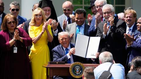 Trump muestra la orden que crea la Comisión de Libertad Religiosa durante un evento en los jardines de la Casa Blanca.