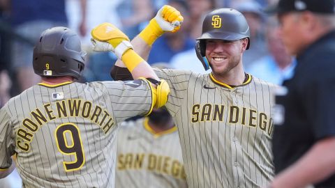 San Diego Padres' Gavin Sheets, right, congratulates Jake Cronenworth who returns to the dugout after hitting a solo home urn off Colorado Rockies starting pitcher Bradley Blalock in the third inning of a baseball game Saturday, May 10, 2025, in Denver. (AP Photo/David Zalubowski)