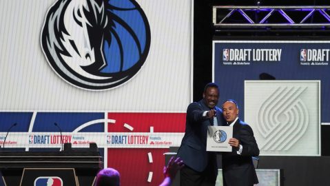 Dallas Mavericks' Rolando Blackman, left, and NBA Deputy Commissioner Mark Tatum, right, pose for photos after Tatum announced that the Mavericks had won the first pick in the NBA draft during the draft lottery in Chicago, Monday, May 12, 2025. (AP Photo/Nam Y. Huh)