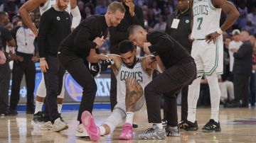 Trainers help Boston Celtics' Jayson Tatum (0) off the court after he was injured during the second half of Game 4 in the Eastern Conference semifinals of the NBA basketball playoffs against the New York Knicks Monday, May 12, 2025, in New York. (AP Photo/Frank Franklin II)