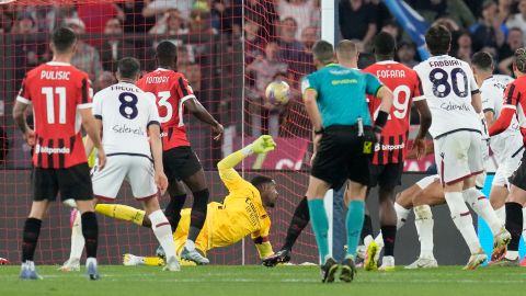 Bologna's Dan Ndoye, right covered, scores past AC Milan's goalkeeper Mike Maignan the opening goal during the Italian Cup final soccer match between AC Milan and Bologna at Rome's Olympic Stadium, Wednesday, May 14, 2025. (AP Photo/Gregorio Borgia)