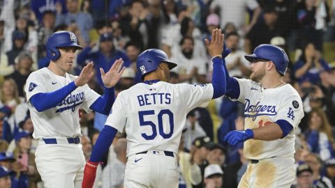 Los Angeles Dodgers' Freddie Freeman, left, Mookie Betts (50) and Max Muncy, right, celebrate after Muncy hit a three-run home run that scored Freeman and Betts in the eighth inning of a baseball game against the Oakland Athletics, Wednesday, May 14, 2025, in Los Angeles. (AP Photo/Jayne Kamin-Oncea)