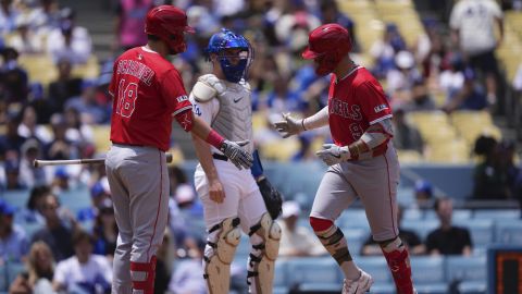 Los Angeles Angels' Zach Neto, right, is congratulated by Nolan Schanuel, left, after hitting a solo home run as Los Angeles Dodgers catcher Will Smith watches during the first inning of a baseball game Sunday, May 18, 2025, in Los Angeles. (AP Photo/Mark J. Terrill)