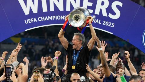 PSG's head coach Luis Enrique holds up the trophy as he celebrates with his players after winning the Champions League final soccer match between Paris Saint-Germain and Inter Milan at the Allianz Arena in Munich, Germany, Saturday, May 31, 2025. (AP Photo/Martin Meissner)