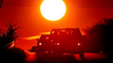 A car comes over a hill as the sun rises in the outskirts of Frankfurt, Germany, Monday, May 3, 2021. (AP Photo/Michael Probst)