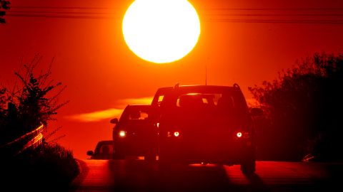 A car comes over a hill as the sun rises in the outskirts of Frankfurt, Germany, Monday, May 3, 2021. (AP Photo/Michael Probst)