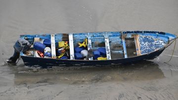 CORRECTS DAY: A boat that capsized sits on the beach Monday, May 5, 2025, in at Torrey Pines State beach in San Diego, Calif. (AP Photo/Denis Poroy)