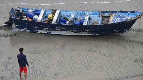 A Del Mar lifeguard looks over a capsized boat on the beach Monday, May. 5, 2025, in at Torrey Pines State beach in San Diego, Calif. (AP Photo/Denis Poroy)