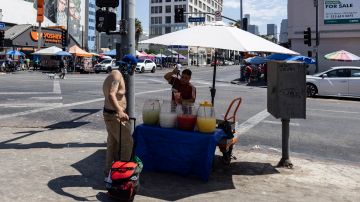 A man buys cold beverages from a street seller near MacArthur Park during a heatwave Friday, Sept. 6, 2024, in Los Angeles. (AP Photo/Etienne Laurent