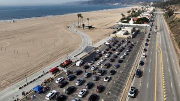Motorists form a queue in a parking lot and along Pacific Coast Highway waiting to enter the Palisades Fire zone Tuesday, Jan. 28, 2025 in Santa Monica, Calif. (AP Photo/Jae C. Hong)