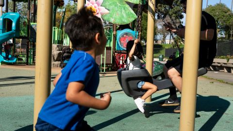 James Avalos y su hija se divierten en un columpió en el Parque Hollenbeck.