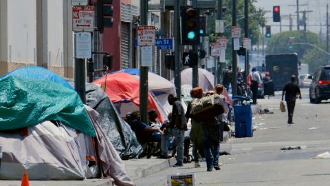 FILE - In this May 30, 2019 file photo, tents housing homeless line a street in downtown Los Angeles. The city of Los Angeles has embarked on an unprecedented effort to bring thousands of homeless residents off the streets and into hotels to protect the most vulnerable amid the coronavirus outbreak. (AP Photo/Richard Vogel, File)