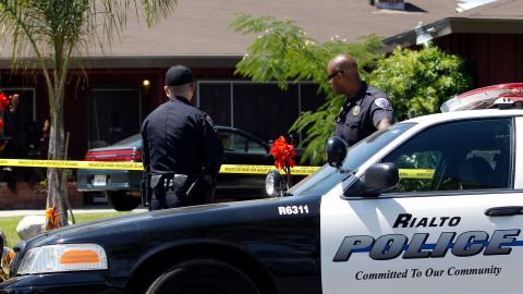 Two police officers stand in front of Rodney King's home in Rialto, Calif., Sunday, June 17, 2012. King, the black motorist whose 1991 videotaped beating by Los Angeles police officers was the touchstone for one of the most destructive race riots in U.S. history, died Sunday. He was 47. King's fiancee called police at 5:25 a.m. to report that she found him at the bottom of the swimming pool at their home in Rialto, California, police Lt. Dean Hardin said. (AP Photo/Jae C. Hong)