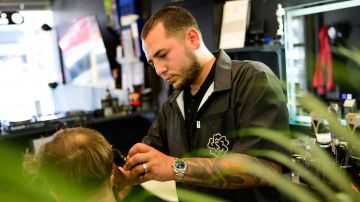 Shalom Styles corta el cabello de uno de sus clientes en Los Ángeles.