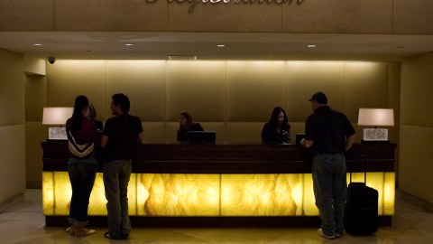 Patrons are seen at the registration desk Wednesday, Oct. 26, 2005, at the Beverly Hilton Hotel in Beverly Hills, Calif. Wall Street expects Hilton Hotels Corp. to report higher earnings Thursday, but roughly flat revenue for the third quarter. Analysts have forecast earnings of 20 cents per share and revenue of $1.06 billion, compared with prior-year earnings of 16 cents a share and revenue of $1.03 billion, according to a Thomson Financial poll. (AP Photo/Damian Dovarganes)