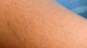 Una mujer muestra tres billetes, de cien, cinco y un dólar.