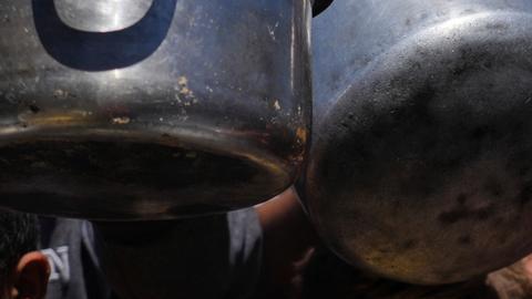 Los palestinos se reúnen en una cocina comunitaria en Khan Younis, en el sur de la Franja de Gaza, donde los residentes dicen que el flujo de ayuda alimentaria aún no llega al norte.
