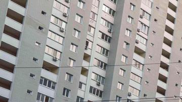 Un hombre limpia los escombros del balcón de su casa dañada por un ataque ruso con drones en Kiev, Ucrania.