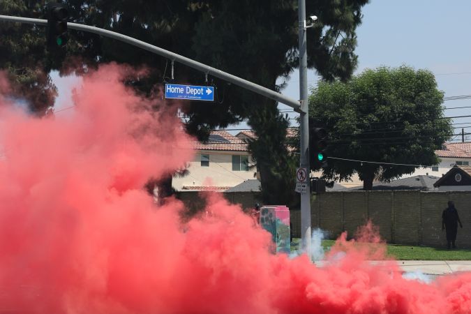 Agentes usan humo contra los manifestantes durante un enfrentamiento cerca de un Home Depot después de una redada de ICE en Paramount, California.