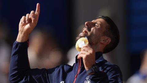 Serbia's Novak Djokovic shows his gold medal after defeating Spain's Carlos Alcaraz in the men's singles tennis final at the Roland Garros stadium during the 2024 Summer Olympics, Sunday, Aug. 4, 2024, in Paris, France. Djokovic has won his first Olympic gold medal by beating Alcaraz 7-6 (3), 7-6 (2) in the 2024 Games men's tennis singles final. (AP Photo/Manu Fernandez)