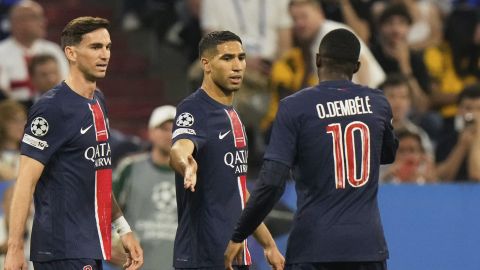 PSG's Achraf Hakimi, center, celebrates with Ousmane Dembele, right, and Fabian Ruiz after scoring the opening goal during the Champions League final soccer match between Paris Saint-Germain and Inter Milan at the Allianz Arena in Munich, Germany, Saturday, May 31, 2025. (AP Photo/Luca Bruno)