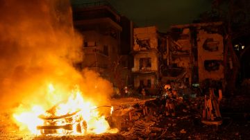 Los bomberos trabajan para extinguir un incendio después de que un misil lanzado desde Irán impactara Tel Aviv.