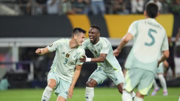 Mexico defender César Montes, left, celebrates his side's second goal with teammate Julián Quiñones during a CONCACAF Gold Cup soccer match against Suriname Wednesday, June 18, 2025, in Arlington, Texas. (AP Photo/Julio Cortez)