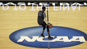 Wyoming's Alan Herndon chases an errant ball across the NCAA logo during practice at the NCAA college basketball tournament in Seattle, Thursday, March 19, 2015. Wyoming plays Northern Iowa in the second round on Friday. (AP Photo/Elaine Thompson)