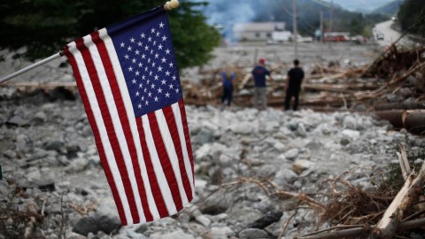 A United States flag hangs near a washed out section of US 4 in Killington, Vt, in the aftermath of Tropical Storm Irene, Wednesday, Aug. 31, 2011. Running low on food and money, Vermont residents stranded by flooded roads relied upon provisions dropped by National Guard troops to get by Wednesday while the rest of the East Coast labored to recover from the wrath of the hurricane-turned-tropical storm known as Irene. (AP Photo/Matt Rourke)