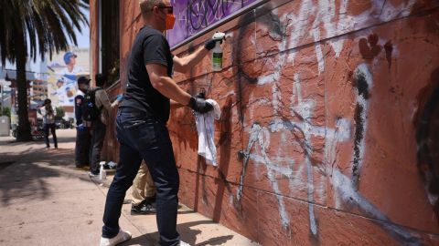 Volunteers remove graffiti from the the Japanese American Museum, Thursday, June 12, 2025, in downtown Los Angeles. (AP Photo/Etienne Laurent)