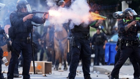 A police officer fires a soft round near the Metropolitan Detention Center in downtown Los Angeles, Sunday, June 8, 2025, following last night's immigration raid protest. (AP Photo/Eric Thayer)