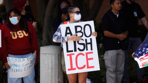 Demonstrators hold signs as they protest, Thursday, June 12, 2025, in Los Angeles. (AP Photo/Etienne Laurent)